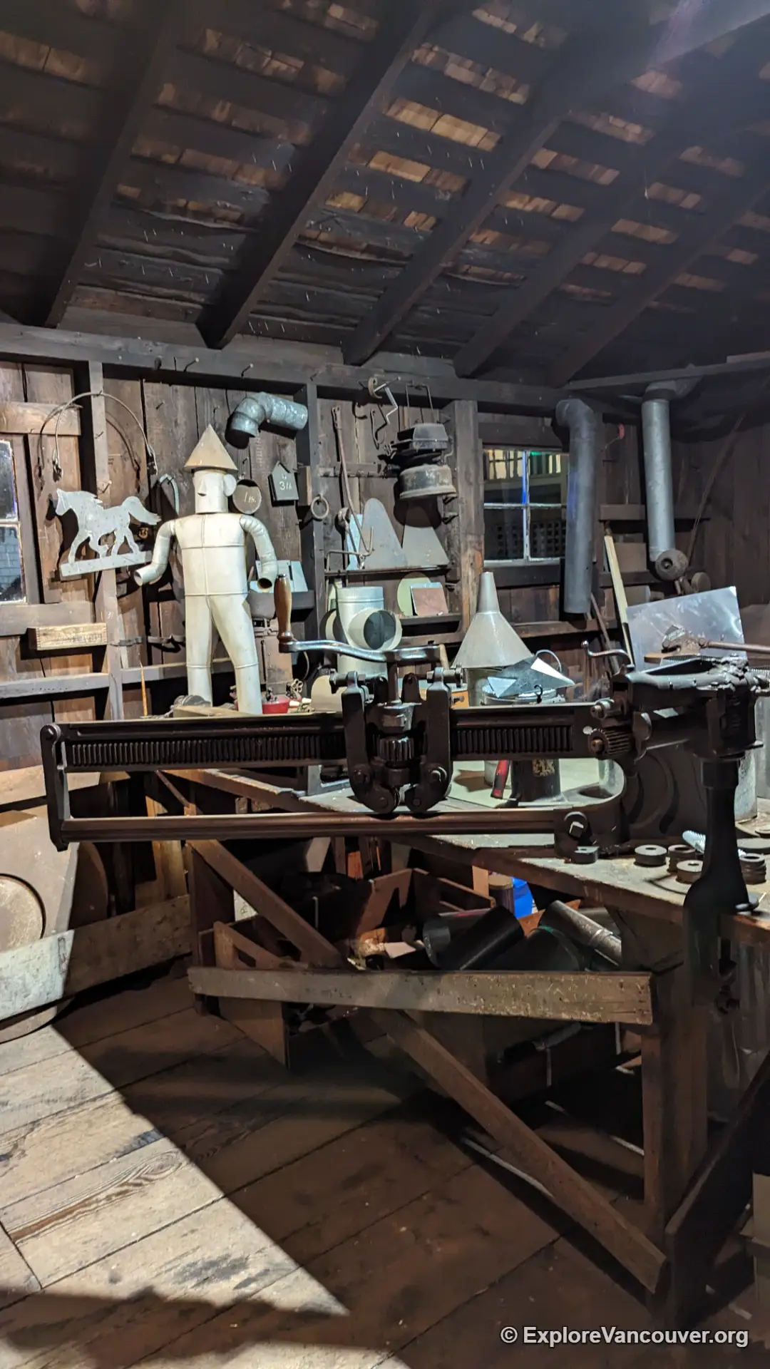 Blacksmith working at the forge inside the heritage blacksmith shop at Burnaby Village Museum