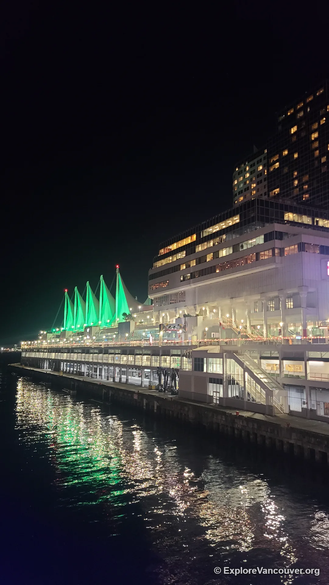Downtown Vancouver skyline lit up at night near Canada Place