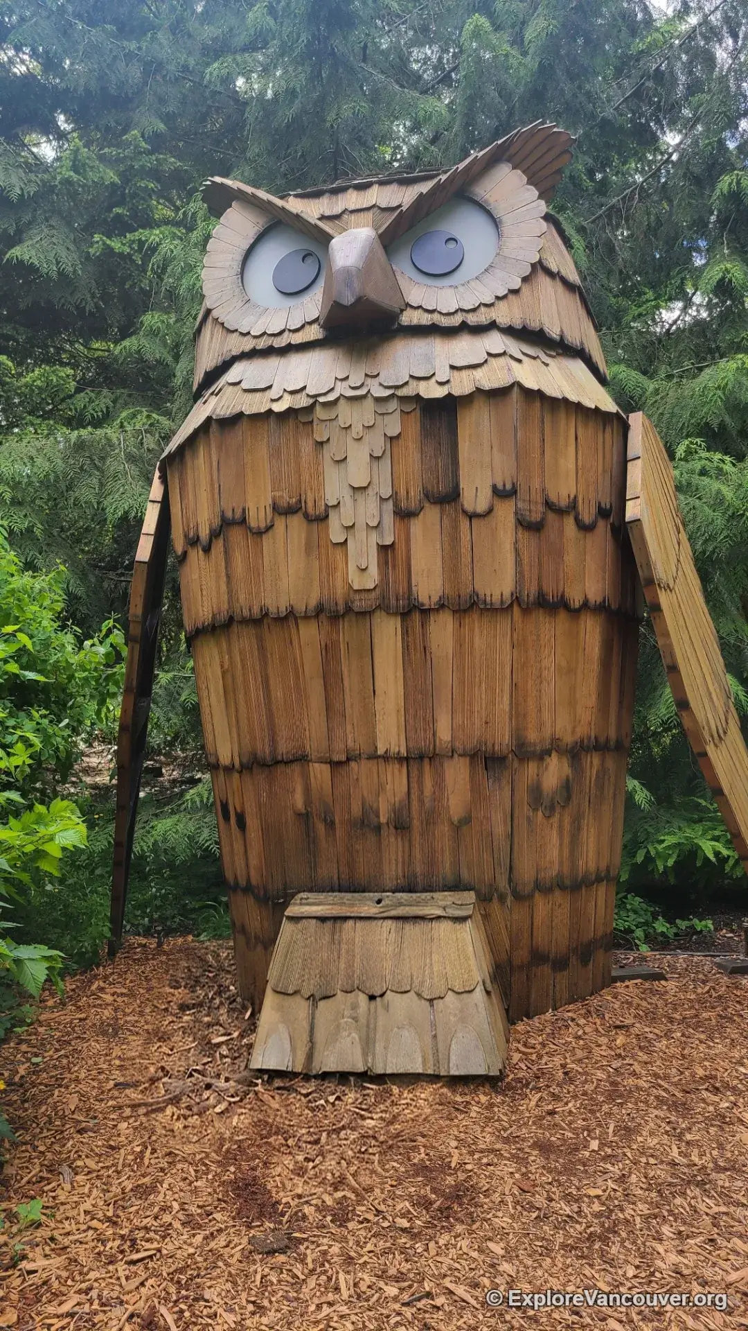 Giant owl sculpture displayed among the trees at VanDusen Botanical Garden