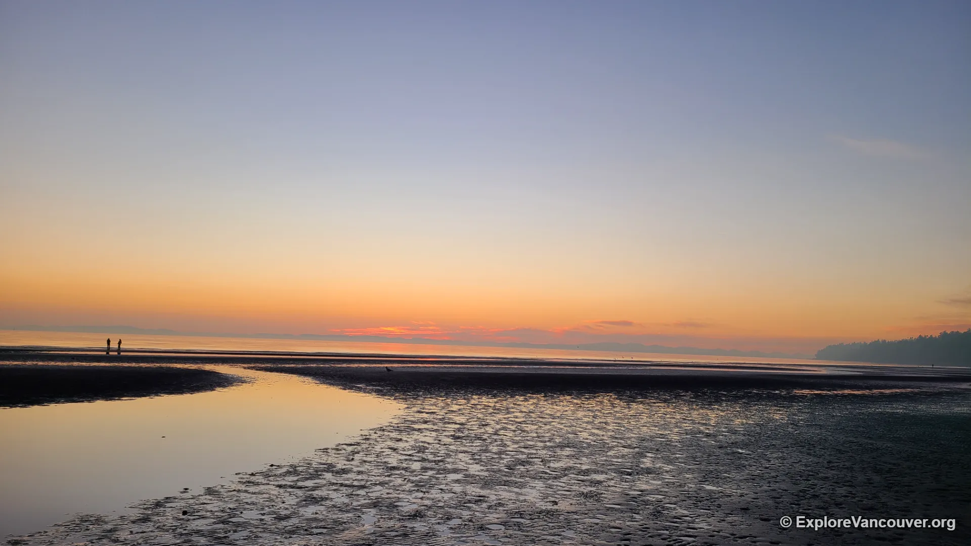 Sunset over the beach beside White Rock Pier with the tide out